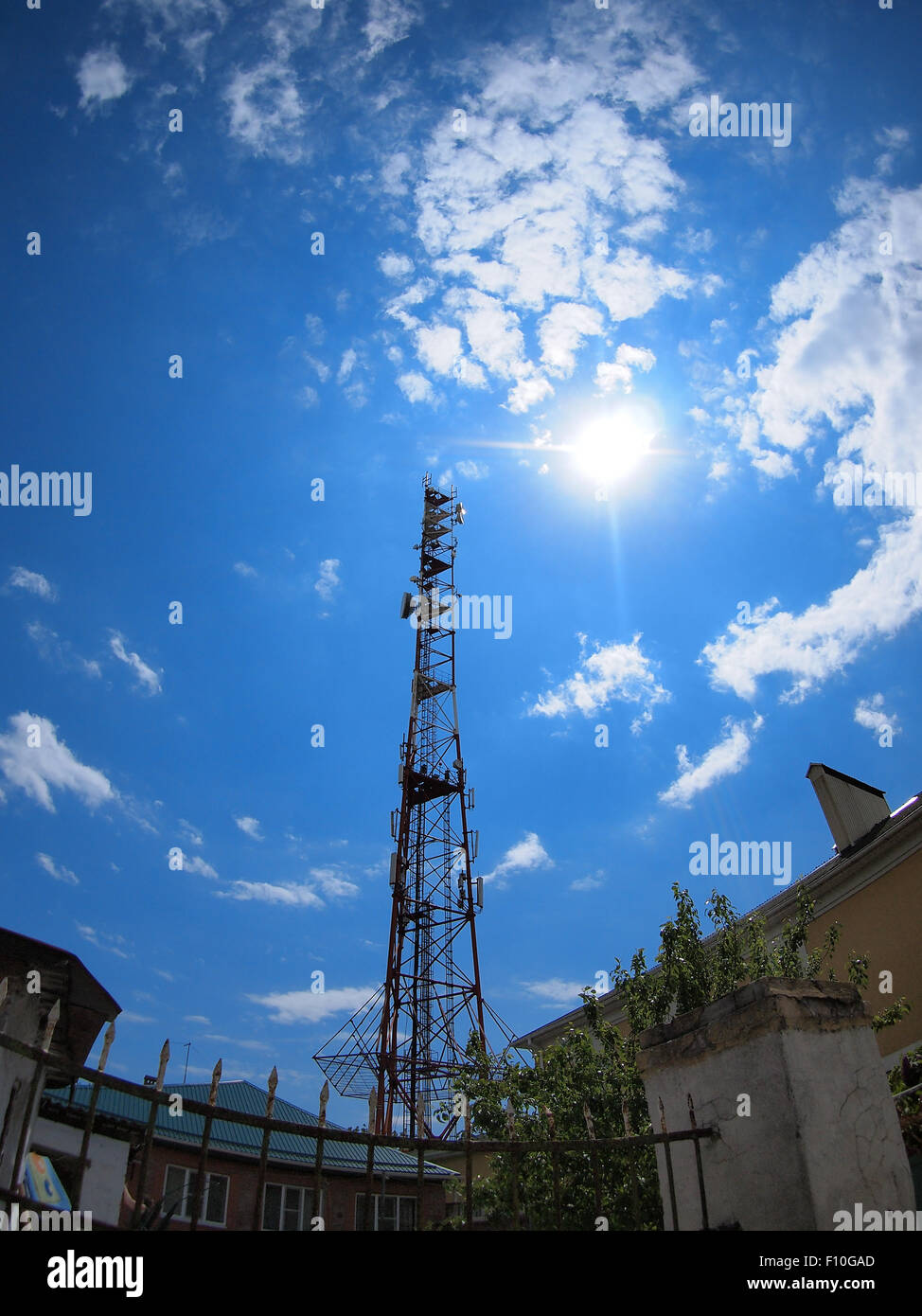 Turm des Mobilfunkes gegen den blauen Himmel und strahlende Sonne mit fisheye-Objektiv und Verzeichnung Weitwinkel Stockfoto