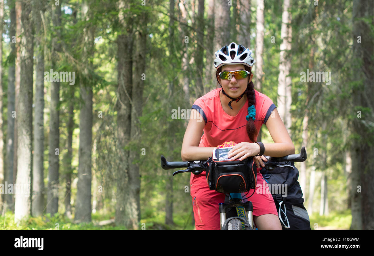 Frau mit dem Fahrrad auf dem Waldlehrpfad im sonnigen Tag Stockfoto