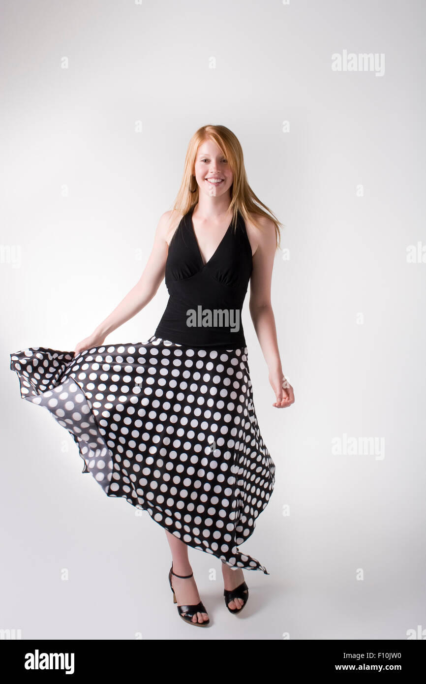 Modell trägt schwarze Bluse und langen schwarzen Rock mit weißen Punkten in  einem studio Stockfotografie - Alamy