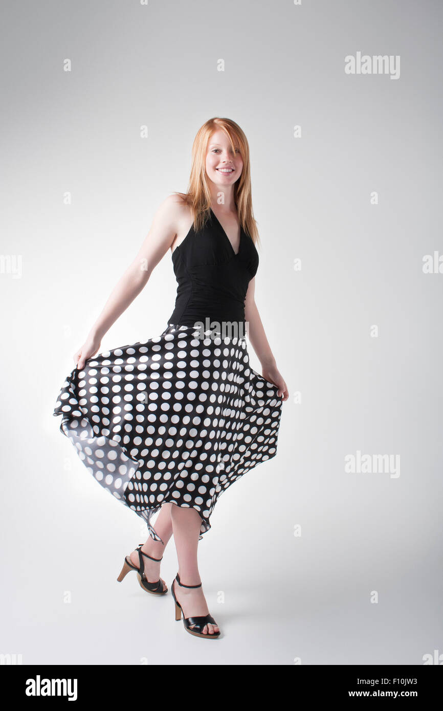 Frau posiert in eine schwarze Bluse, lange Blakc Rock mit weißen Punkten  und schwarzen heels Stockfotografie - Alamy