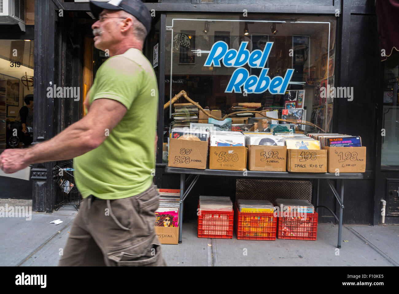 New York City, USA, man Walking, Urban, Old Records Vinyl Music Store, Sign 'Rebel, Rebel' an der Bleecker Street, Shopping in Greenwich Village, Neighbourhood Shop Front Window, Business Records Shops aus den 1980er Jahren Stockfoto