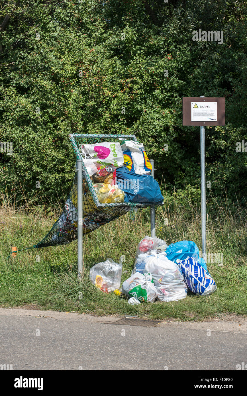 Illegale Ablagerung von Haushalt Müllsäcke in Net Straßenrand bedeutete für das werfen in Dosen und Plastikflaschen Stockfoto