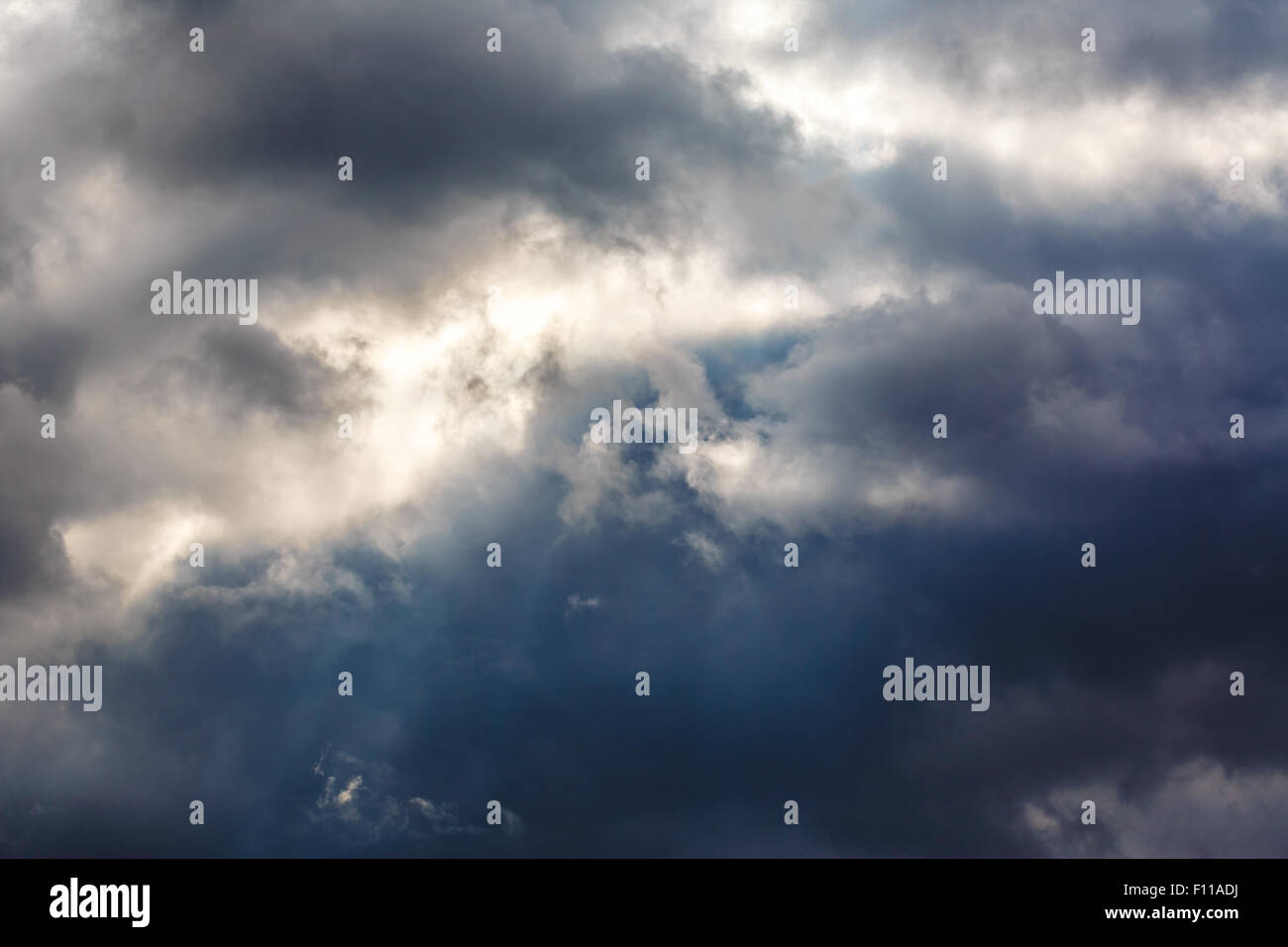 Dunkle Wolken als Hintergrund mit Sonnenstrahlen Stockfoto