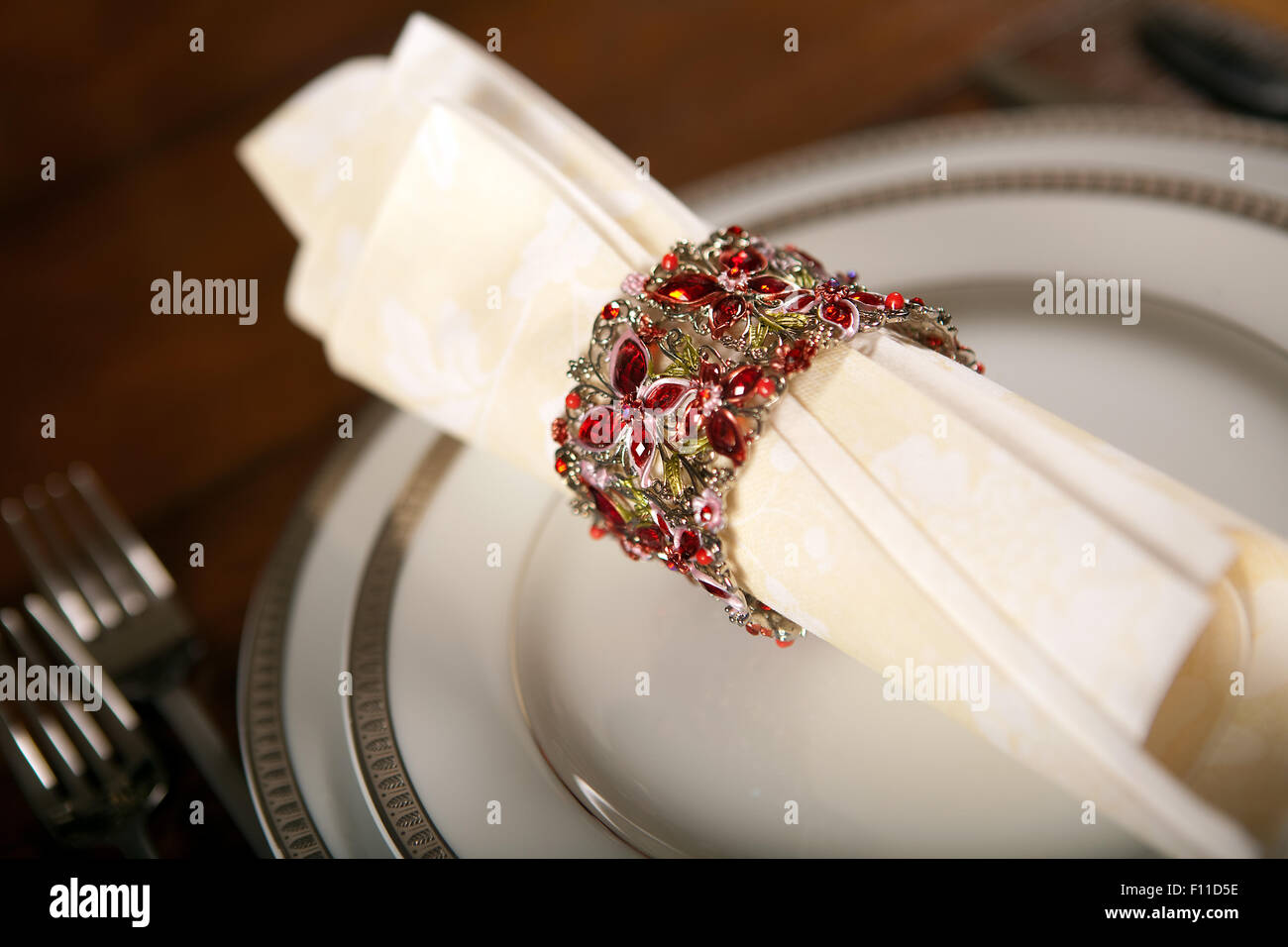 Creme farbigen festliche Serviette mit verzierten Phantasie Serviettenring auf einen Urlaub Tisch Stockfoto