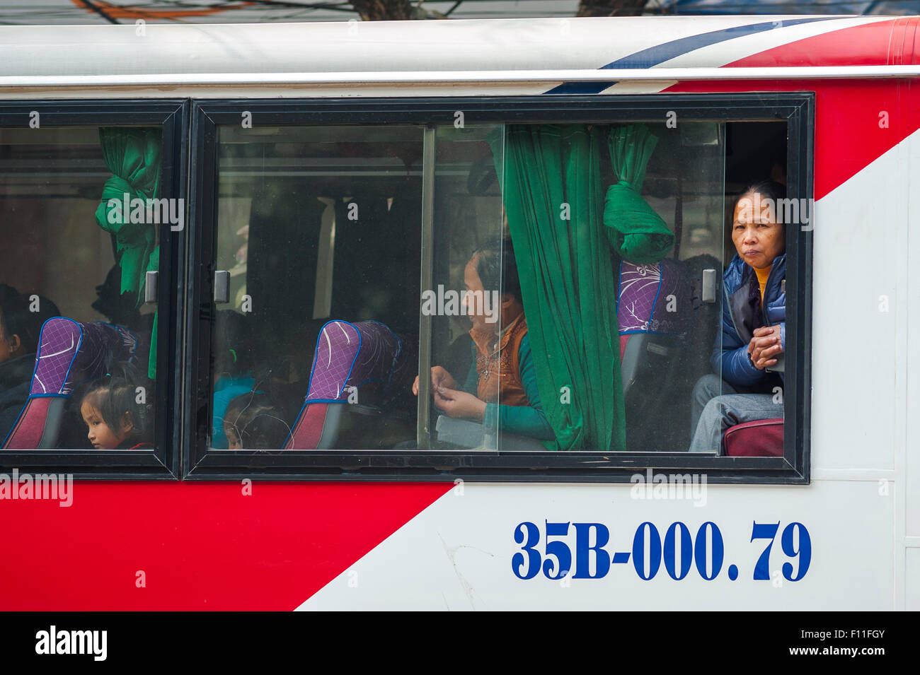 Bus Vietnam Personen, eine Vietnamesin aus einem Bus sieht so aus, als es zu einem Stillstand in dichtem Verkehr im Zentrum von Hanoi, Vietnam. Stockfoto