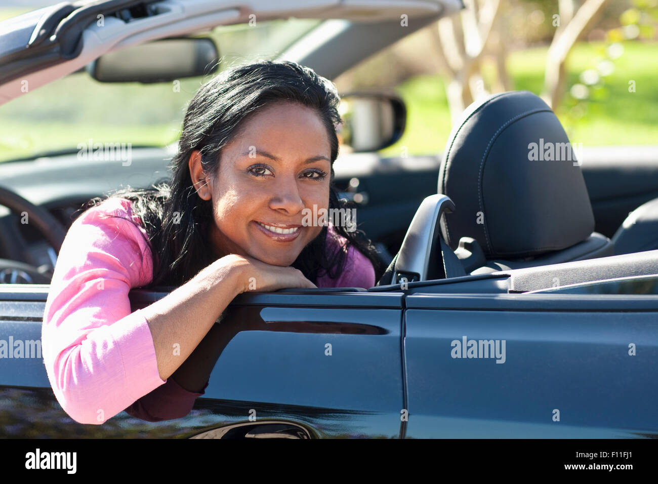 Indische Frau lächelnd in Cabrio Stockfoto