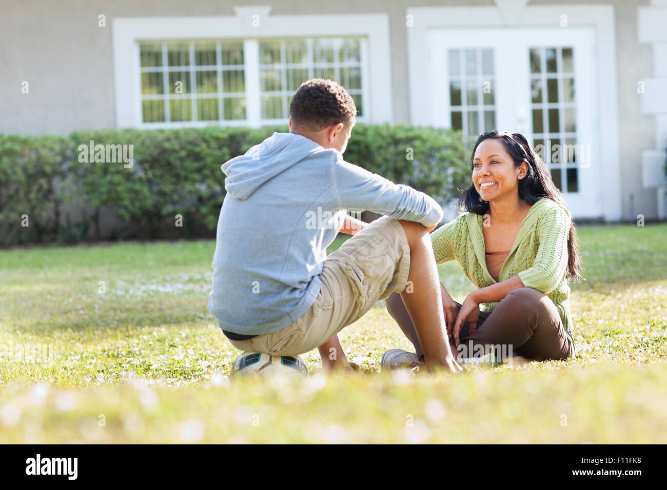 Mutter und Sohn sprechen im Hinterhof Stockfoto