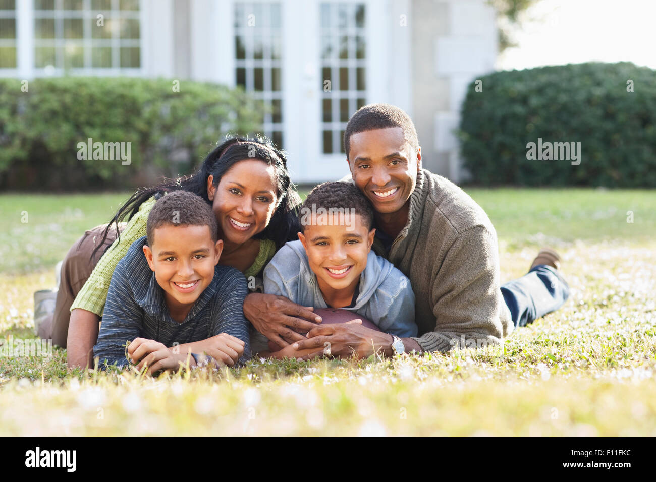 Lächelnde Familie spielen im Hinterhof Stockfoto