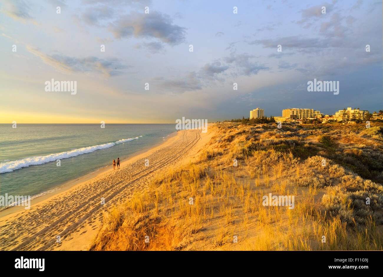 Ein paar in den späten Nachmittag Sommersonne Scarborough Strand entlang spazieren. Perth, Western Australia, Australia Stockfoto