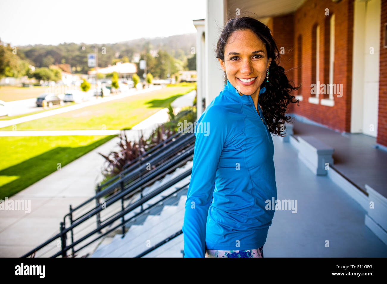 Hispanic Frau lächelnd auf Terrasse Stockfoto