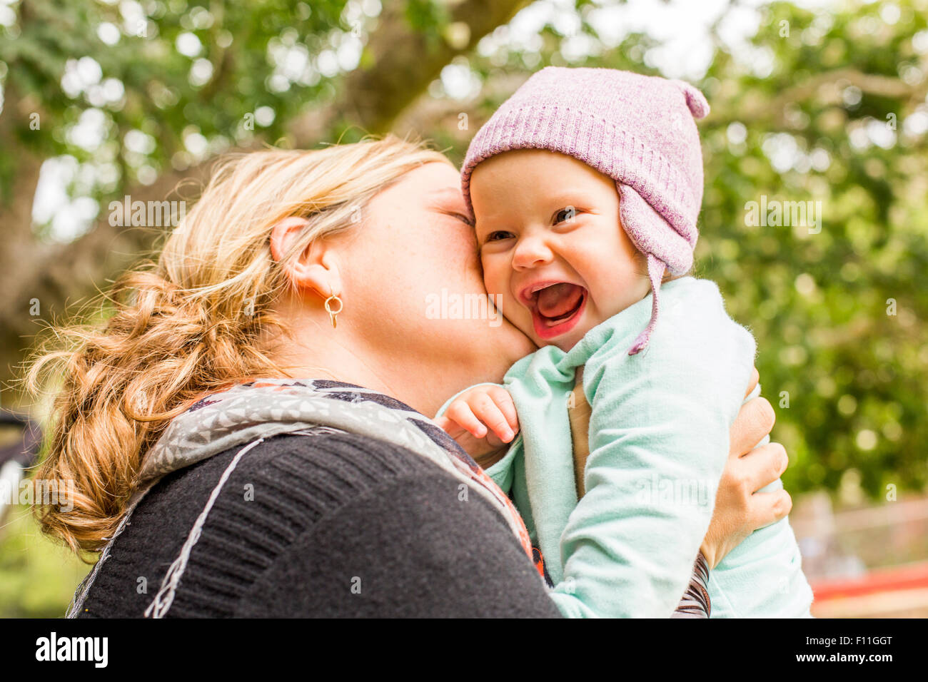 Kaukasische Mutter küssen Baby Tochter im freien Stockfoto