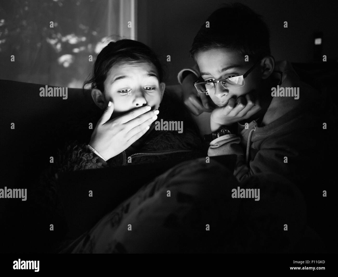 Gemischte Rassen Kinder mit digital-Tablette in der Nacht Stockfoto