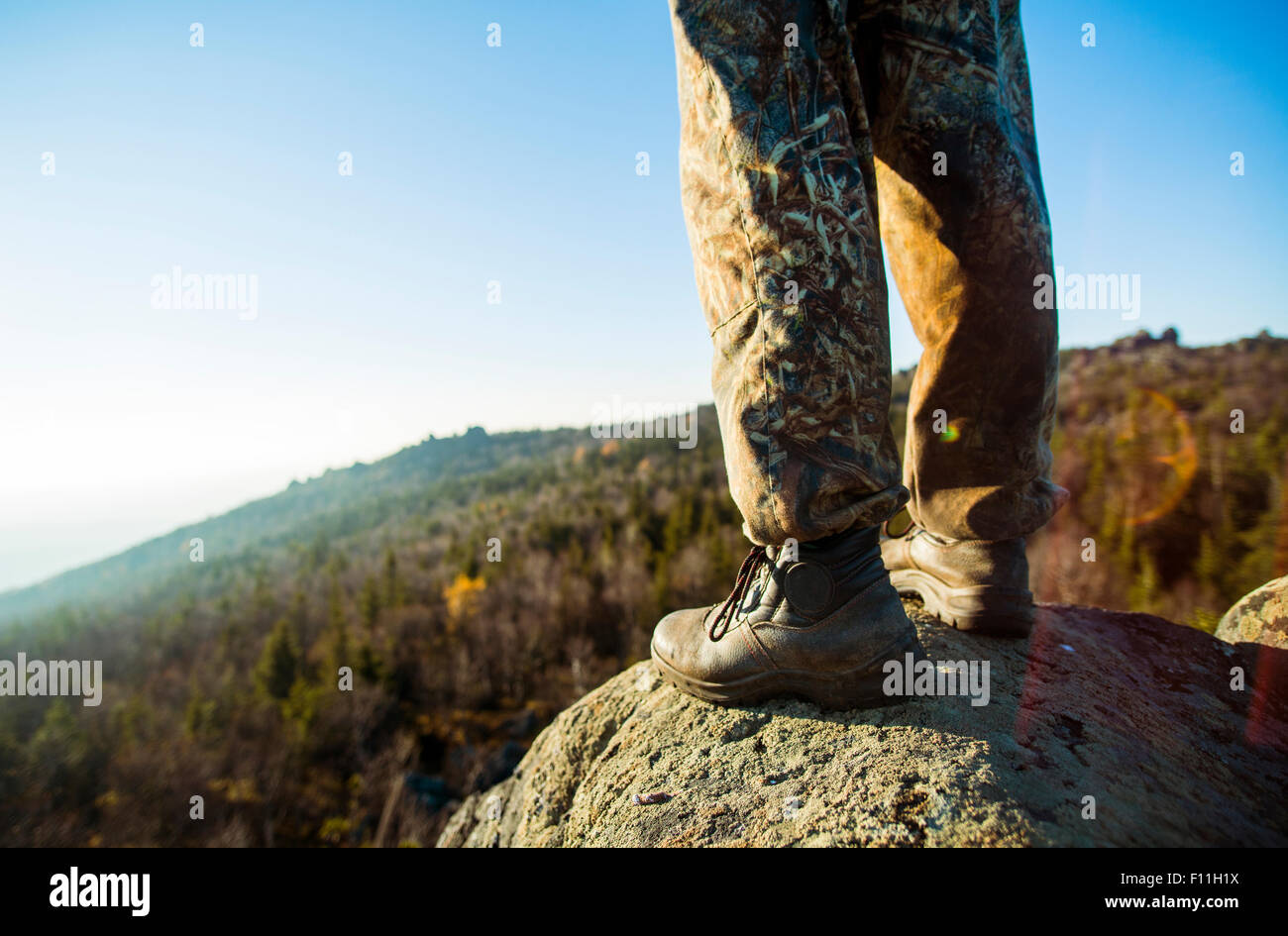 Nahaufnahme von Wanderer auf entfernten Felsen Stockfoto