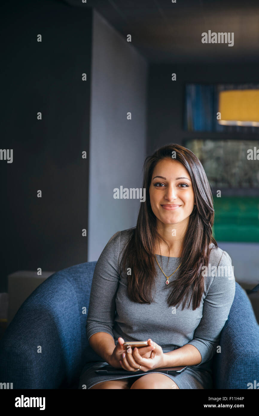 Gemischte Rassen Geschäftsfrau hält Handy im Büro lobby Stockfoto