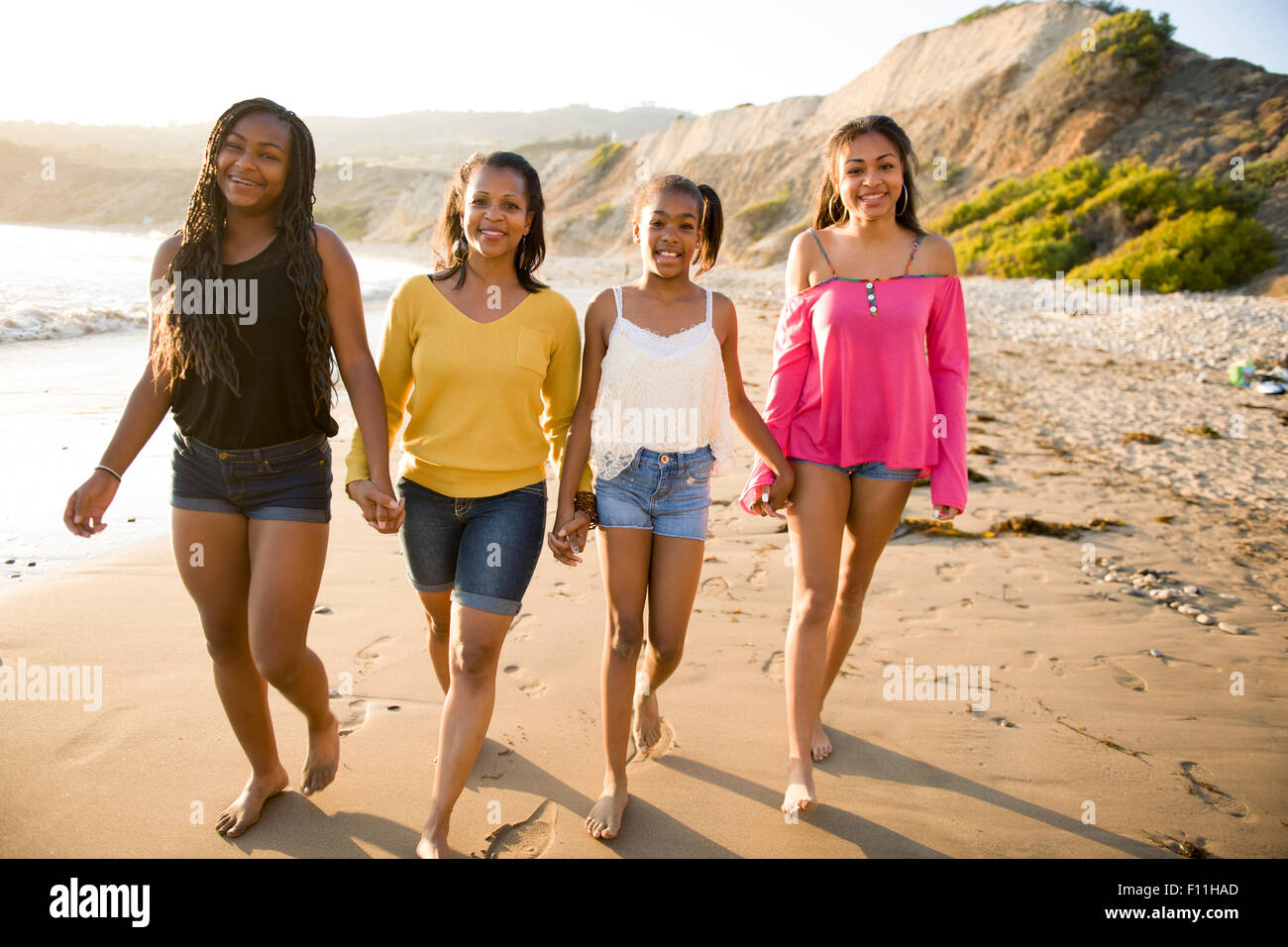 African American Mutter und Töchter zu Fuß am Strand Stockfoto