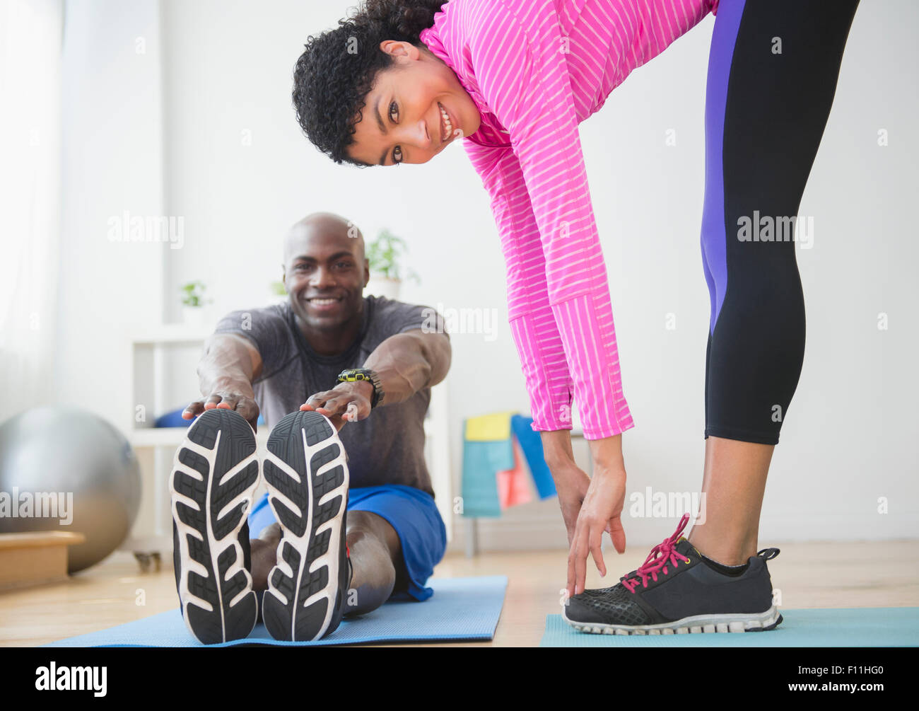 Paar stretching im Fitness-Studio Stockfoto