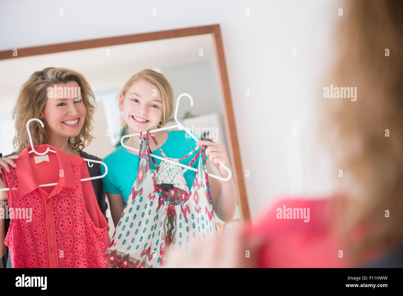 Kaukasische Mutter und Tochter Prüfung Shirts im Spiegel Stockfoto