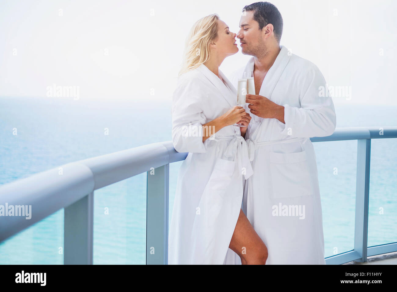 Paar küssen mit Champagner auf Balkon Stockfoto