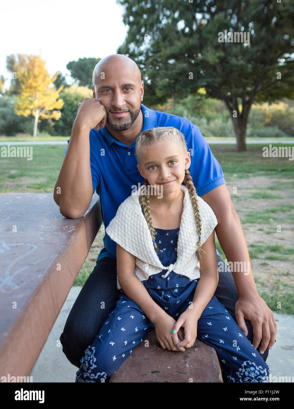 Vater und Tochter lächelnd auf Picknick-Tisch im park Stockfoto