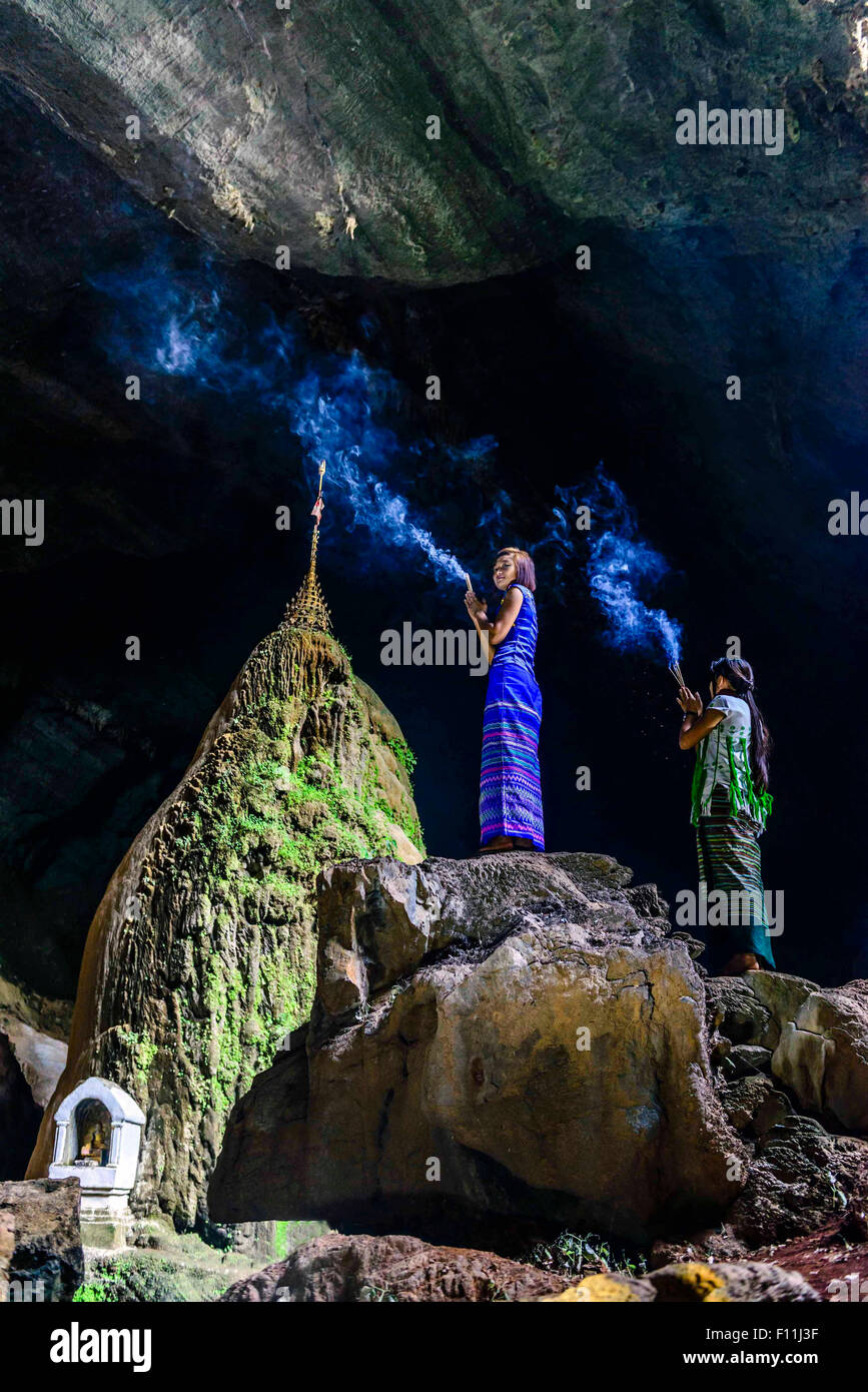 Asiatische Frauen Weihrauch auf Felsformation im cave Tempel Stockfoto