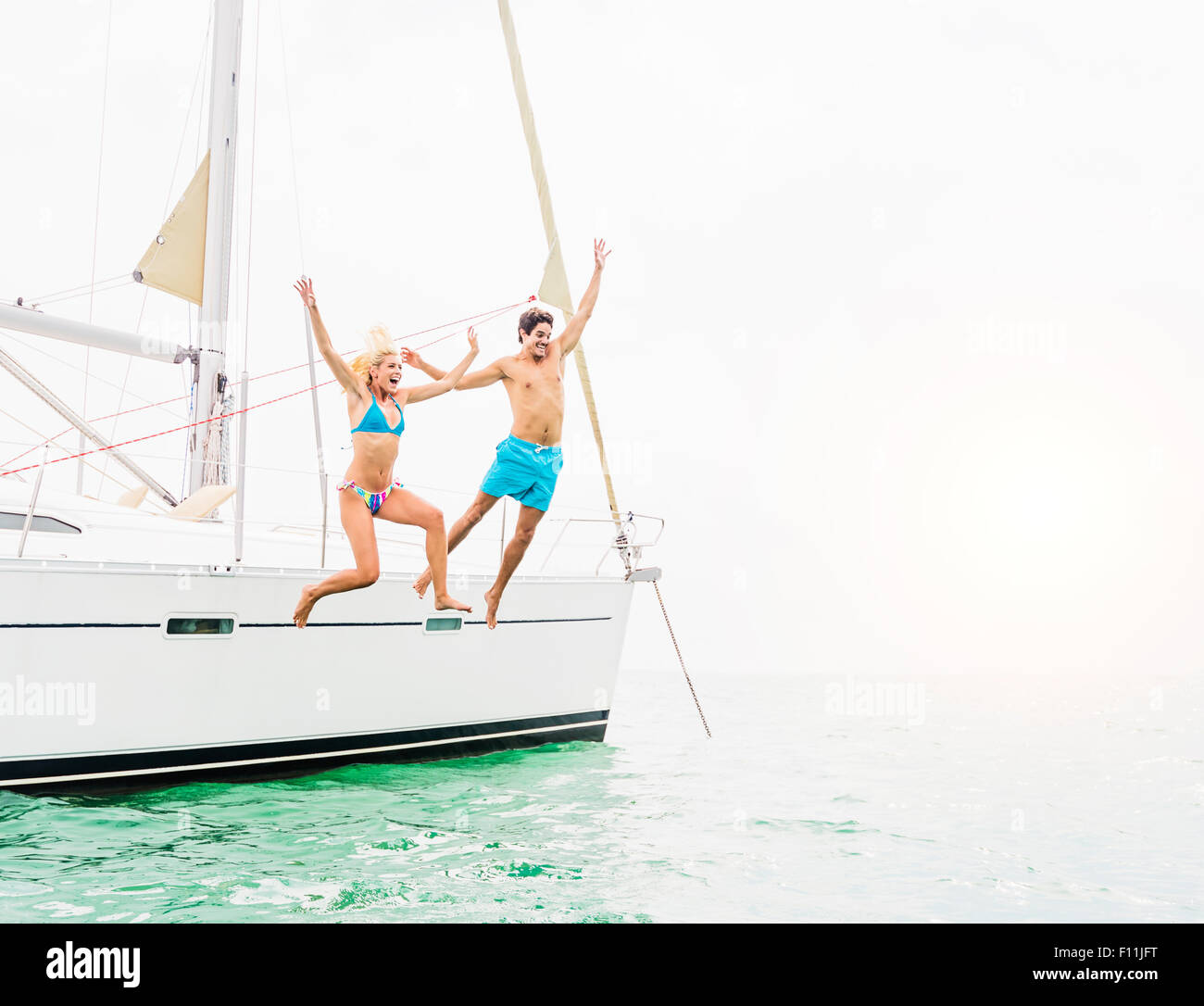 Paar springen vom Segelboot Stockfoto