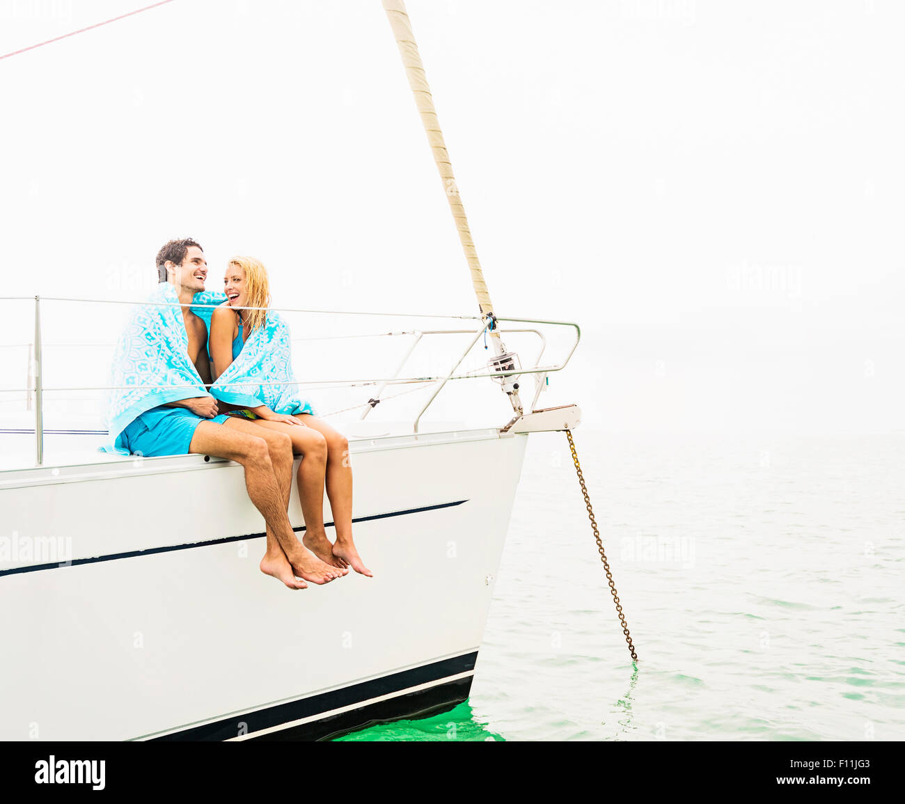 Paar eingewickelt in Tücher auf Deck Segelboot Stockfoto