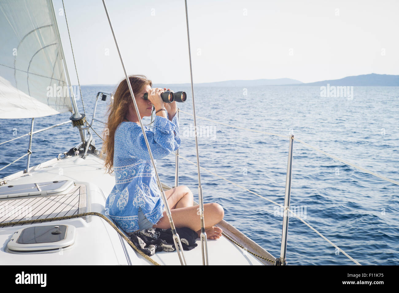 Kaukasische Frau mit dem Fernglas auf Bootsdeck Stockfoto