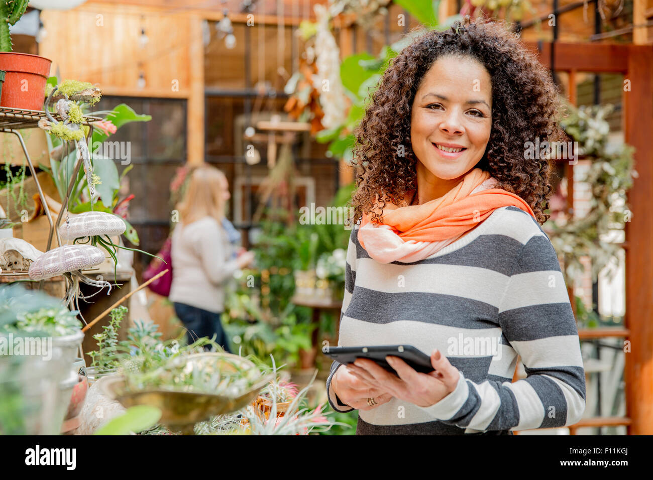 Gemischte Rassen Mitarbeiter mit digital-Tablette in Gärtnerei Stockfoto