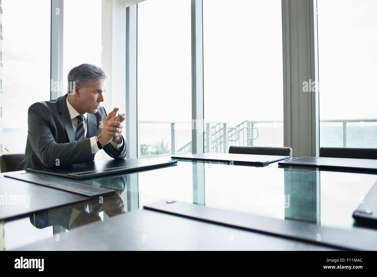 Kaukasische Geschäftsmann am leeren Konferenztisch sitzen Stockfoto