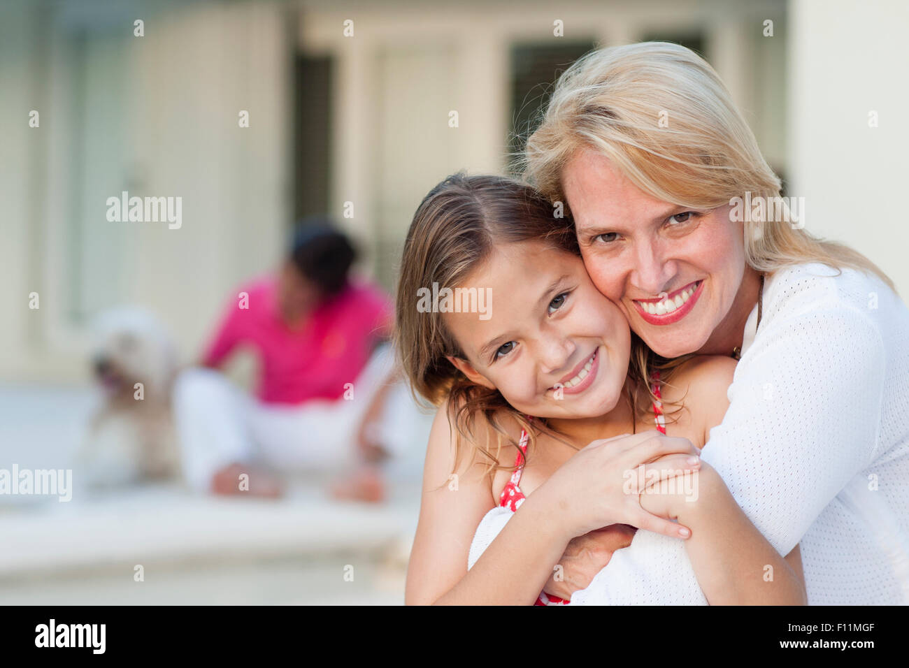 Lächelnde Mutter und Tochter umarmt im freien Stockfoto