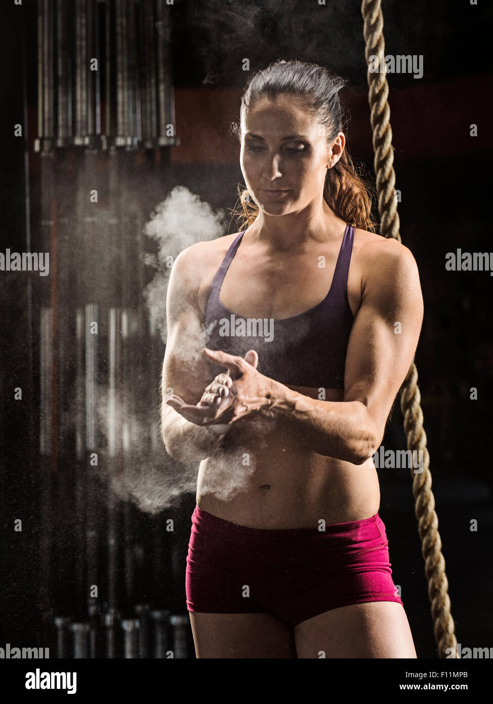 Kaukasische Athlet Kreidung ihre Hände im Fitness-Studio Stockfoto