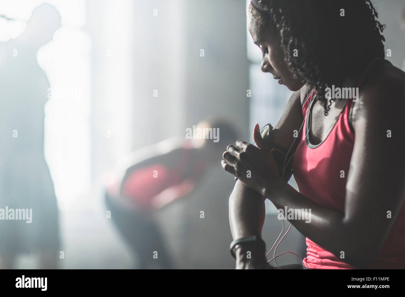 Sportler, die Anpassung der MP3-Player Armbinde im Fitness-Studio Stockfoto