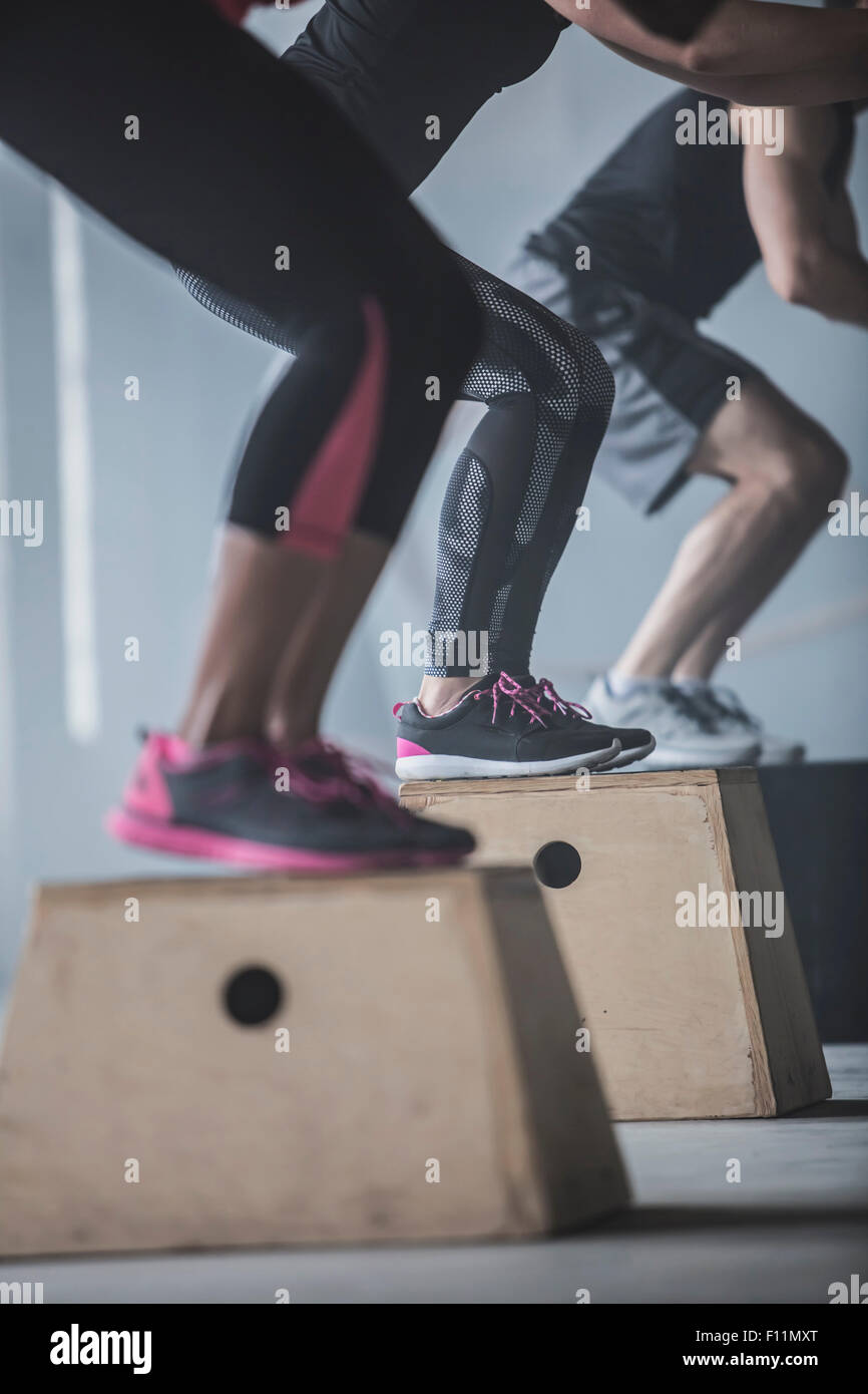 Athleten springen auf Plattformen im Fitness-Studio Stockfoto