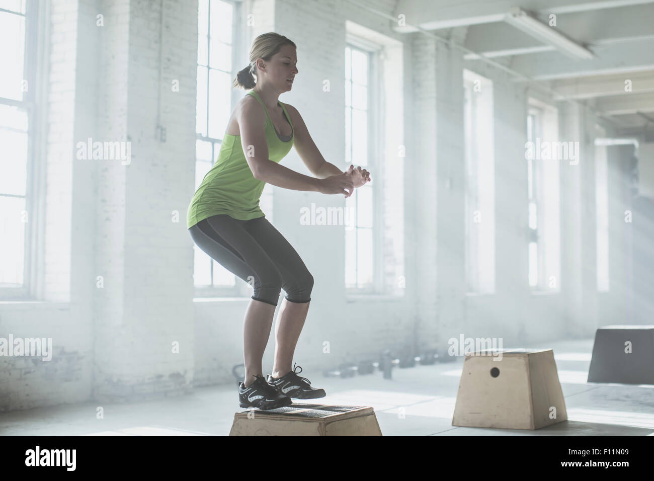 Sportler, die springen auf die Plattform im Fitness-Studio Stockfoto