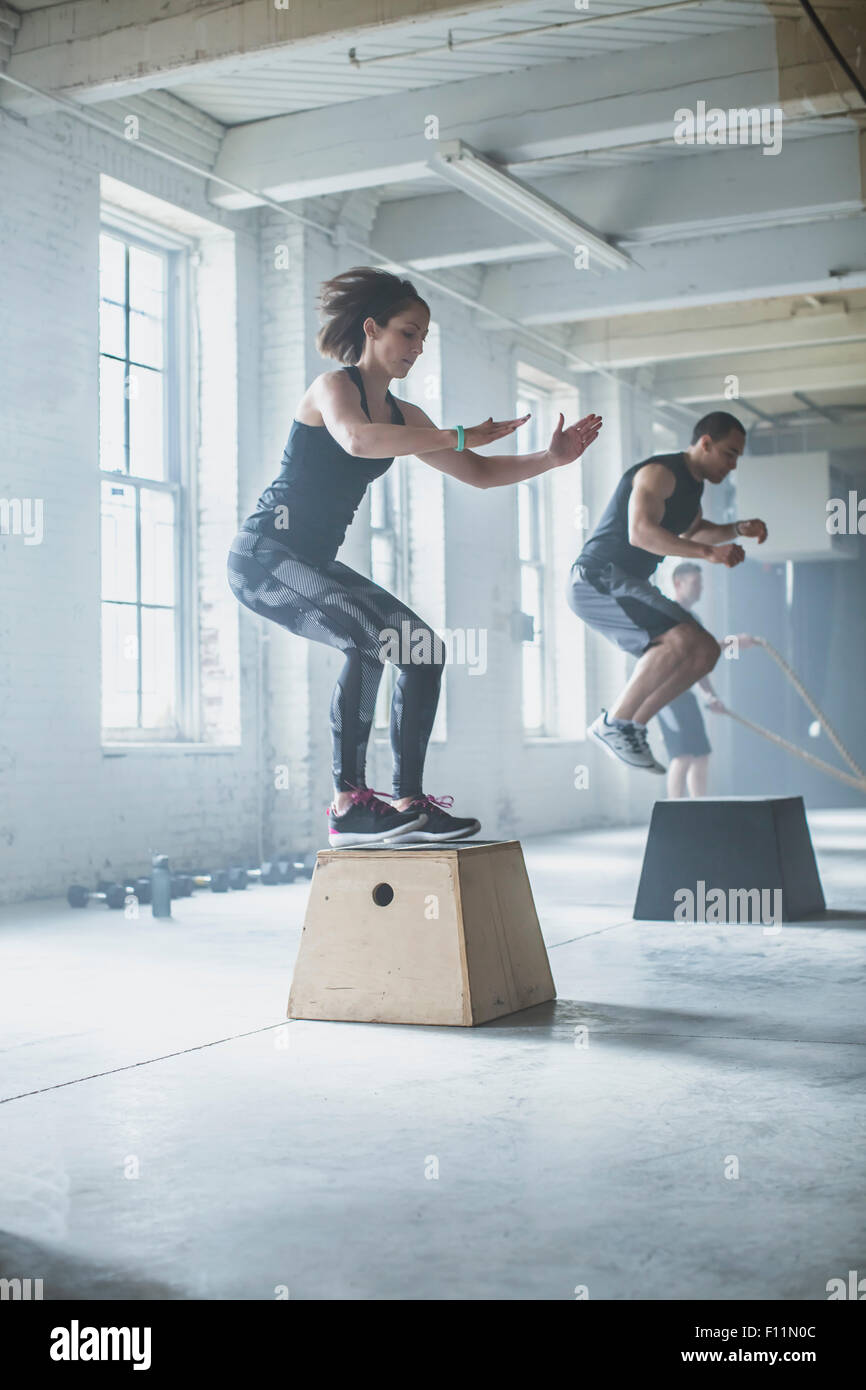 Athleten springen auf Plattformen im Fitness-Studio Stockfoto