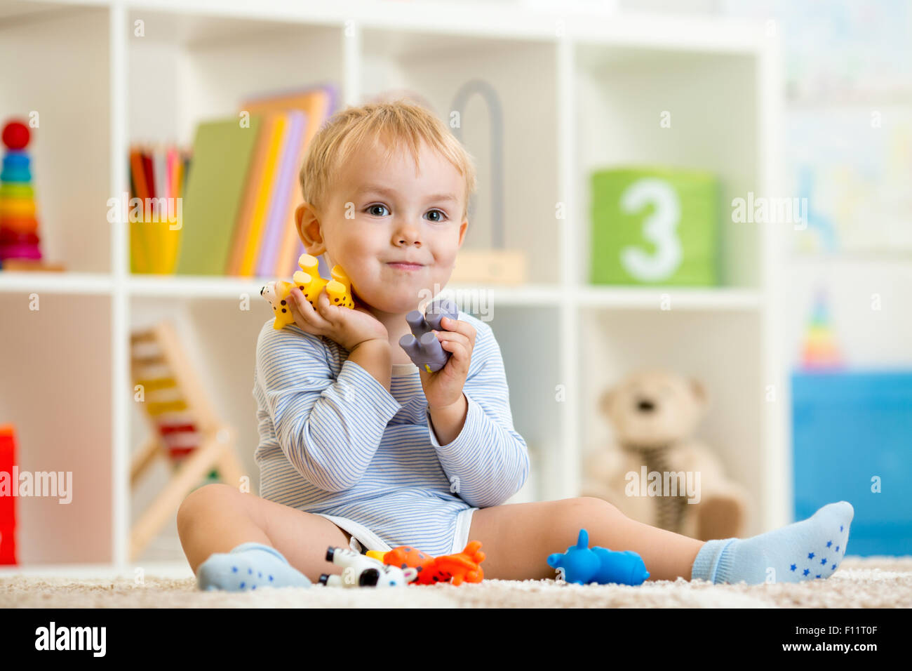 kleines Kind Junge spielt mit Spielzeug Tiere Stockfoto