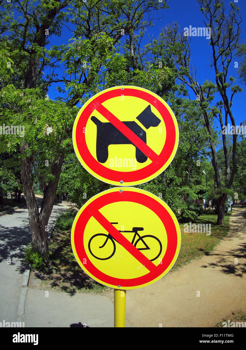 Verbot der Zeichen keine-Hunde und keine-Bikes im Park fotografiert sonnigen Sommertag mit Weitwinkel fisheye-Objektiv und Verzerrung Stockfoto