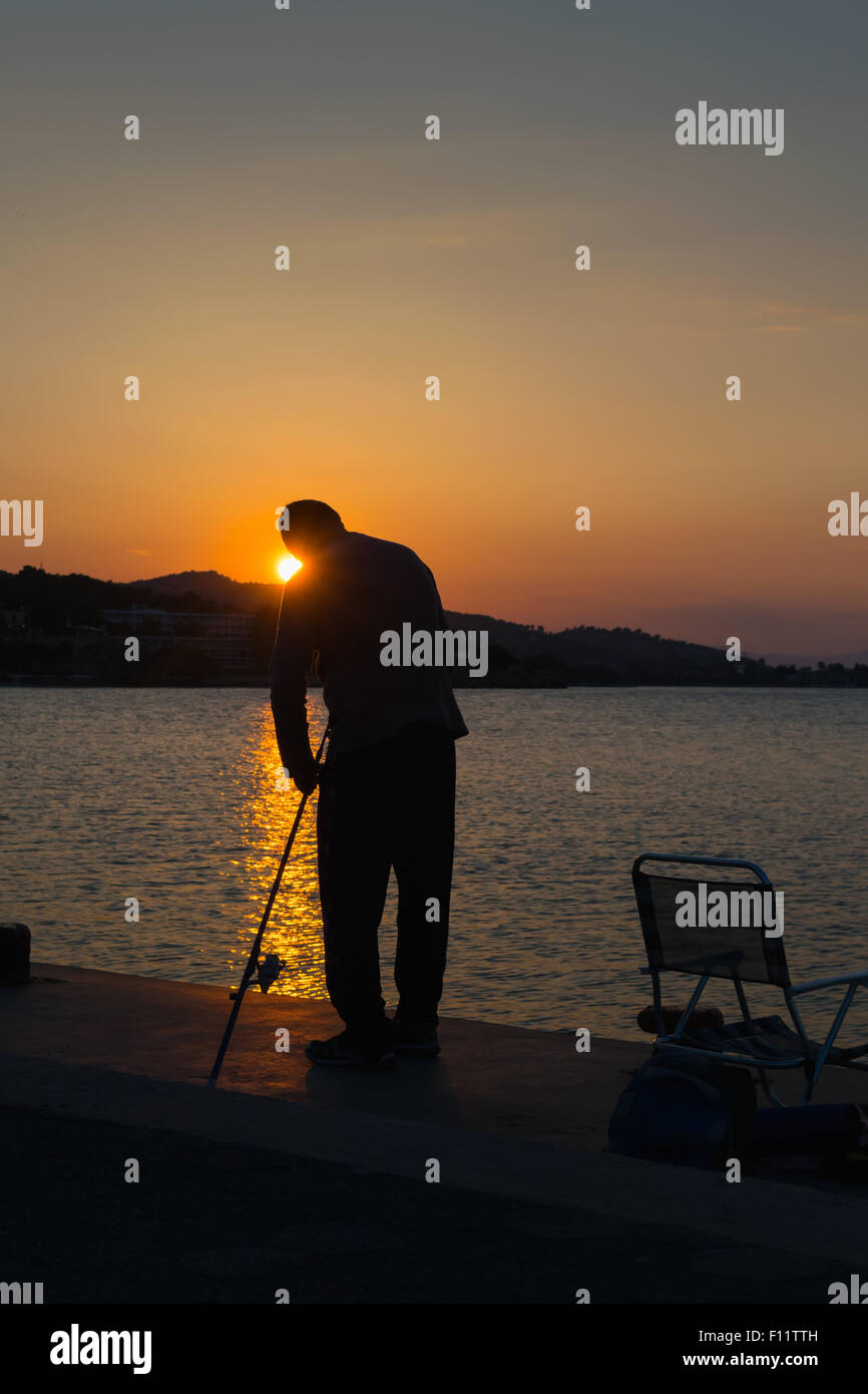 Fischer-Silhouette gegen den Sonnenuntergang. Stockfoto