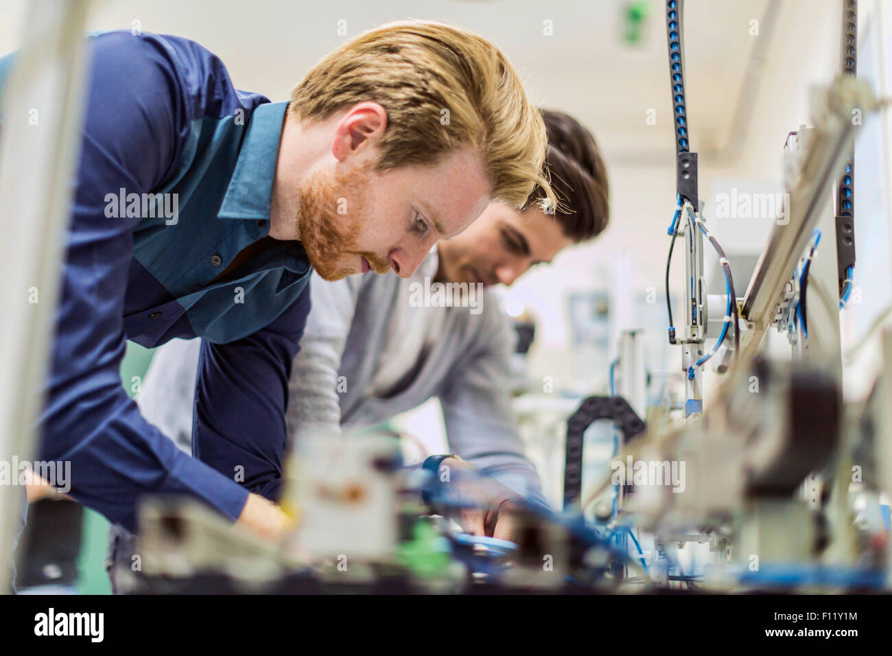 Zwei junge hübsche Ingenieure arbeiten an Elektronikkomponenten und reparieren defekte chips Stockfoto