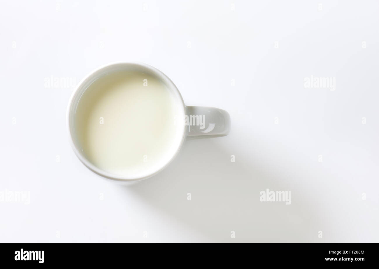 Becher Milch auf weißem Hintergrund Stockfoto