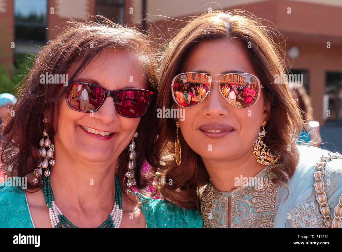 Outdoor Portrait von zwei britischen indischen Frauen das Tragen von Sonnenbrillen Stockfoto