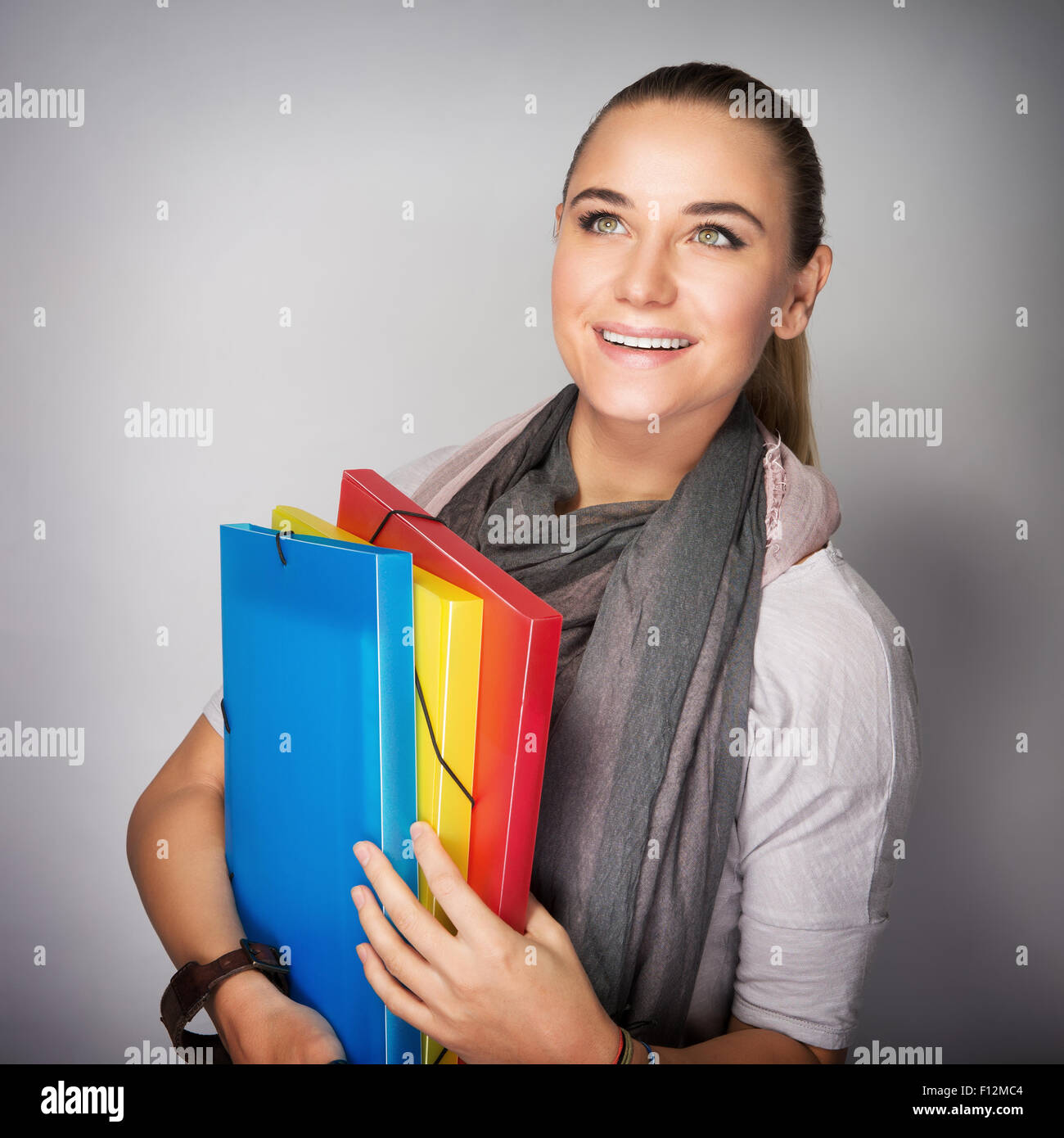 Porträt von nette Studentin stand im Studio über grauen Hintergrund mit Staunen nachschlagen Stockfoto