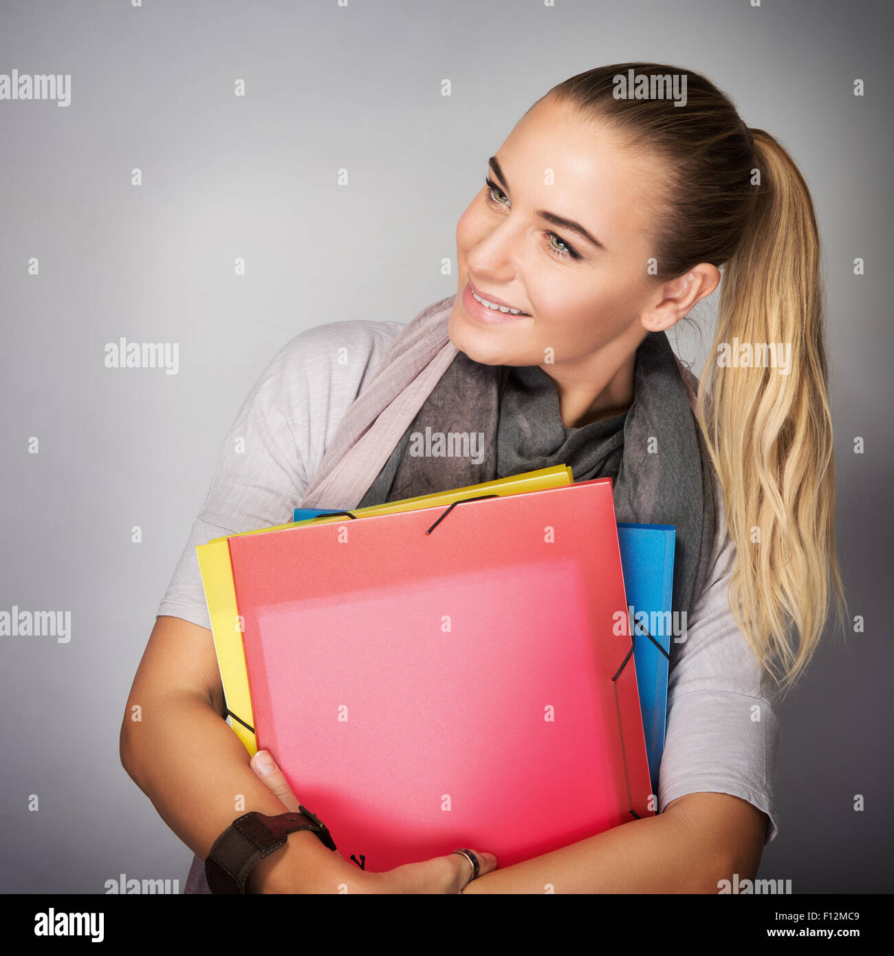 Porträt von nette Studentin im Studio über grauen Hintergrund mit Staunen auf Seite stehen Stockfoto