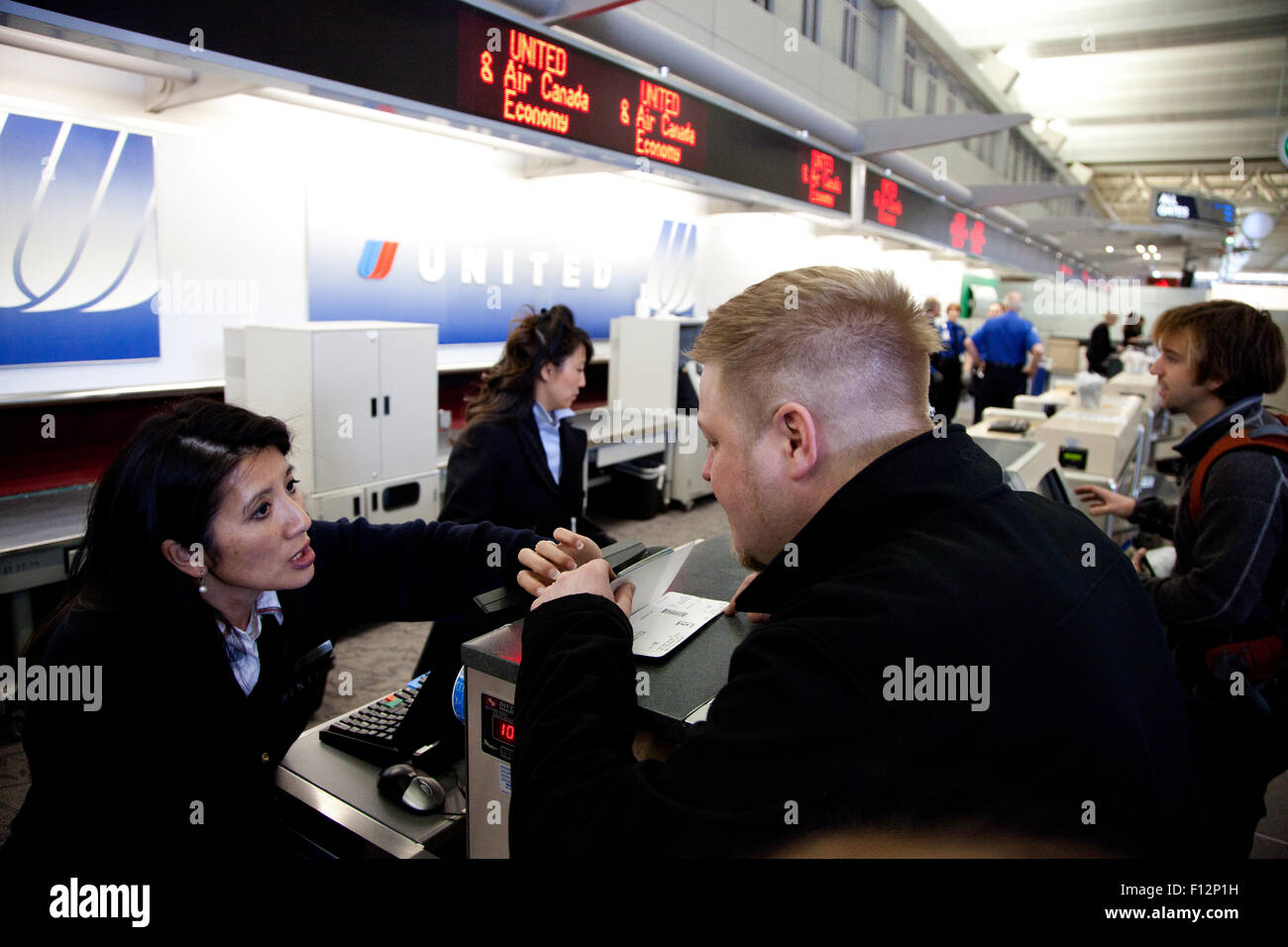Frau Begleiter hilft Mann am Flughafen-Check-in-Schalter. Minneapolis Minnesota MN USA Stockfoto