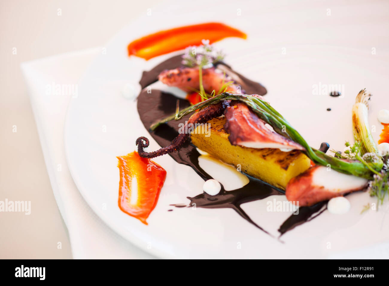 Gegrillter Tintenfisch mit gebratenen Tomaten, Taggiasca Oliven und rote Pfeffer, Tydes Restaurant, Coral Casino, Biltmore Hotel, Santa Barb Stockfoto