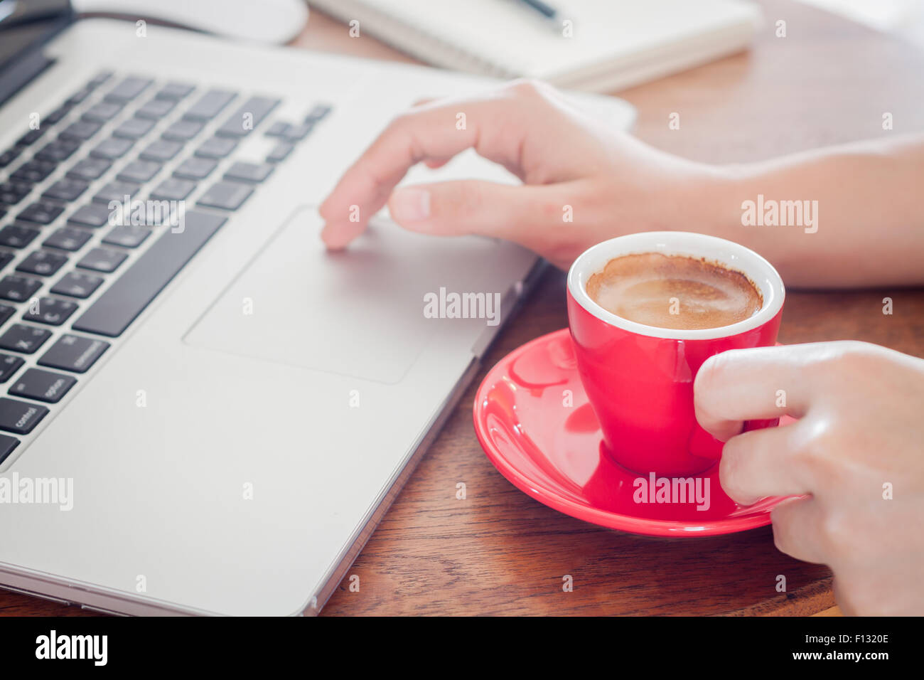 Rote Kaffeetasse mit Notizblock und Laptop, Fotoarchiv Stockfoto