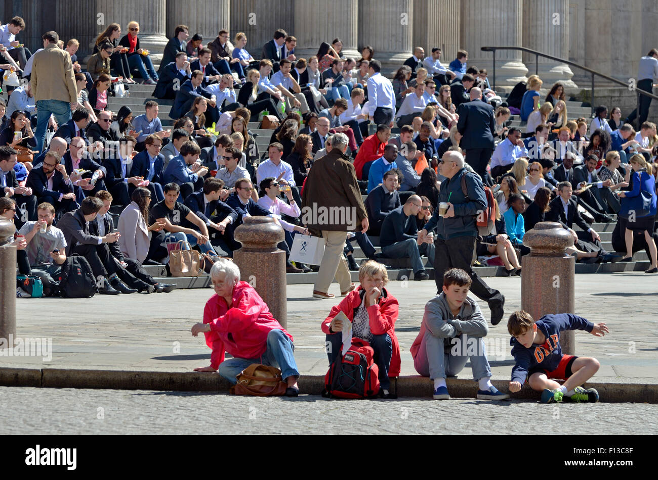 London, England, Vereinigtes Königreich. Leute sitzen in der Sonne auf den Stufen der St. Pauls Cathedral Stockfoto