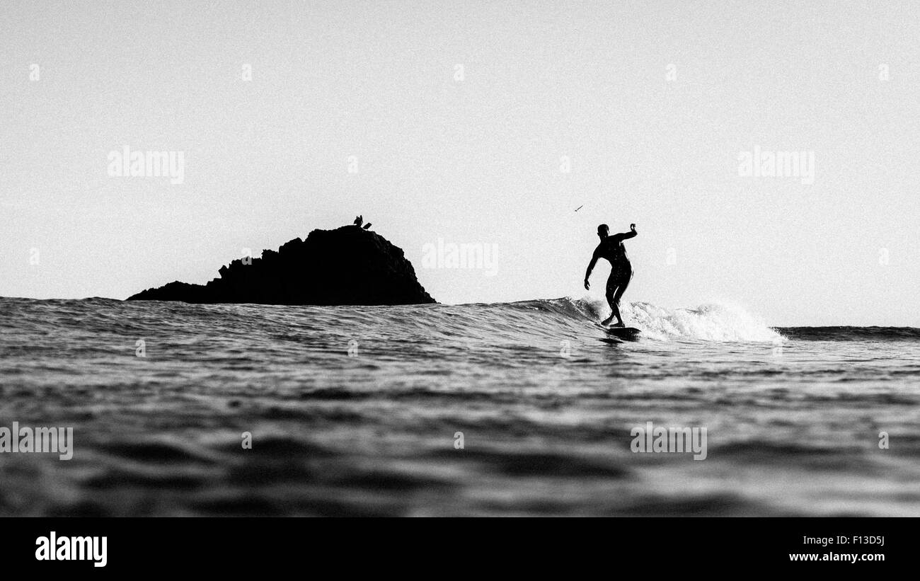 Silhouette eines Mannes Surfen Stockfoto