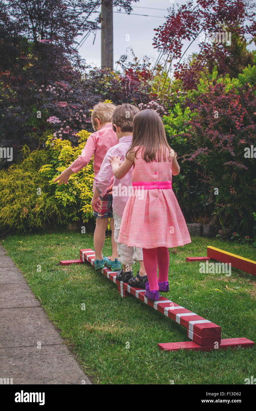 Drei Kinder zu Fuß auf Holzstab Stockfoto