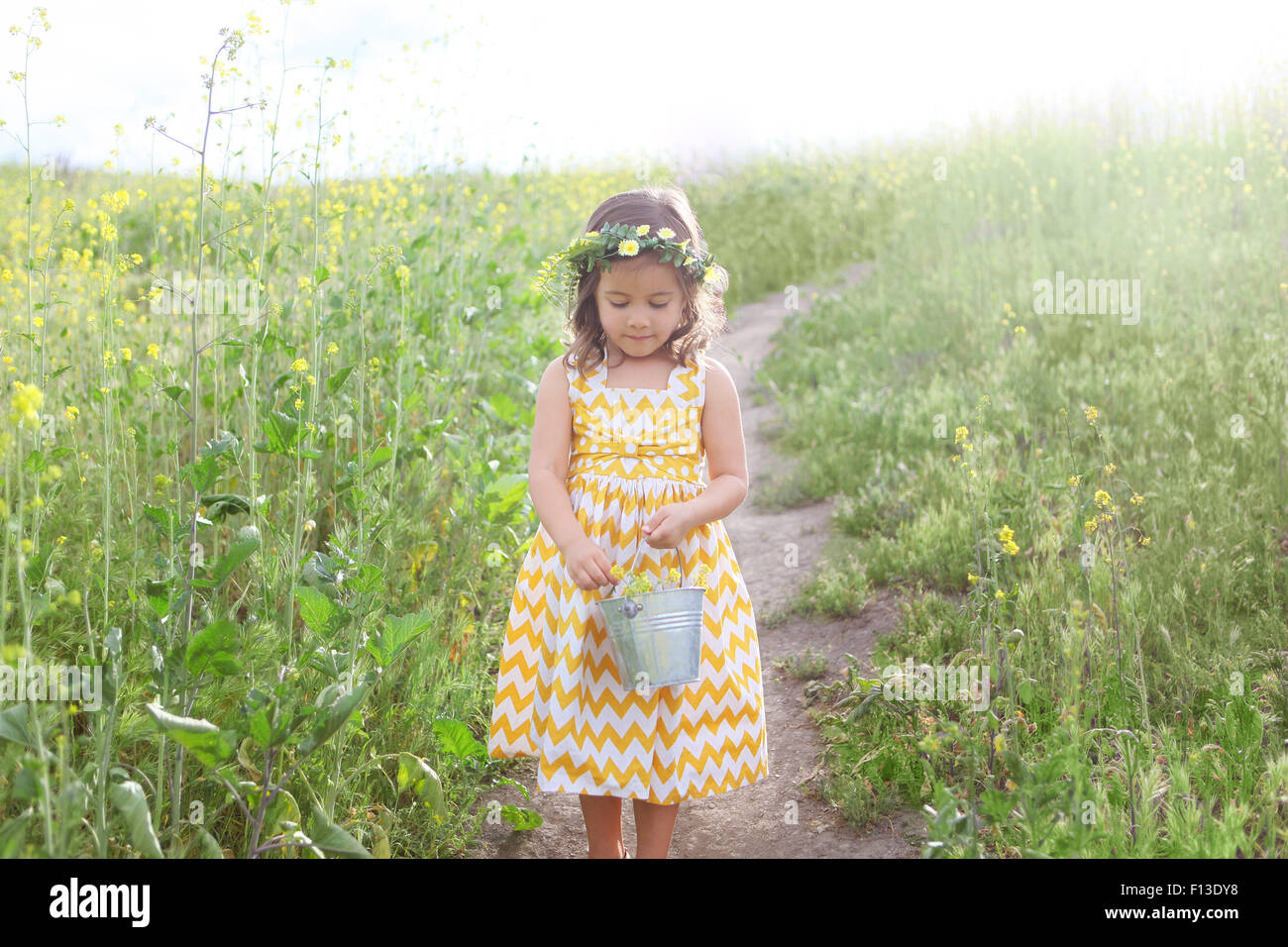 Mädchen hält einen Eimer voller Blumen Stockfoto